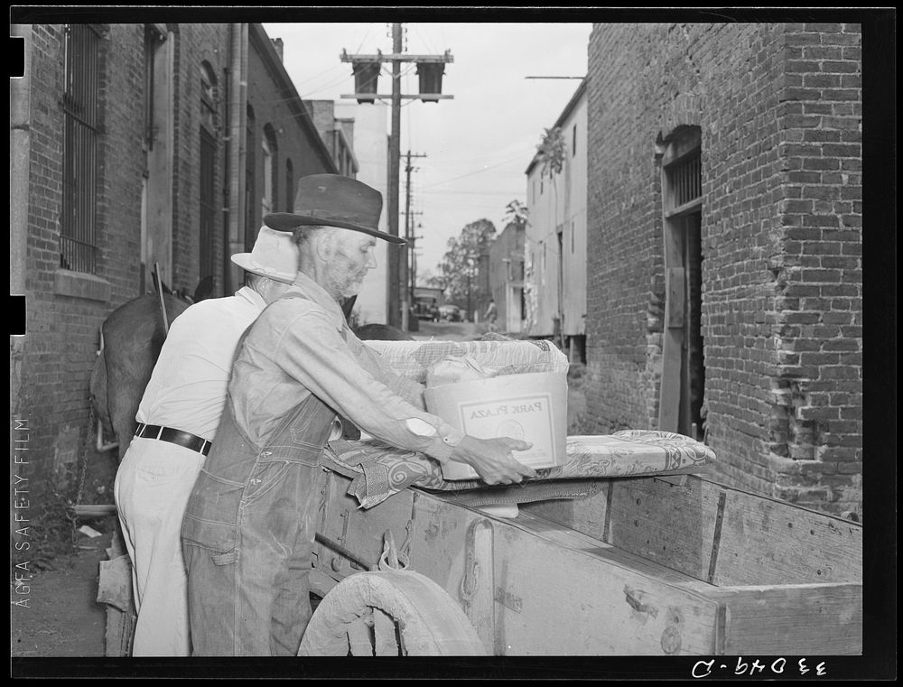 Farmer loading wagon in alley. San Augustine, Texas by Russell Lee