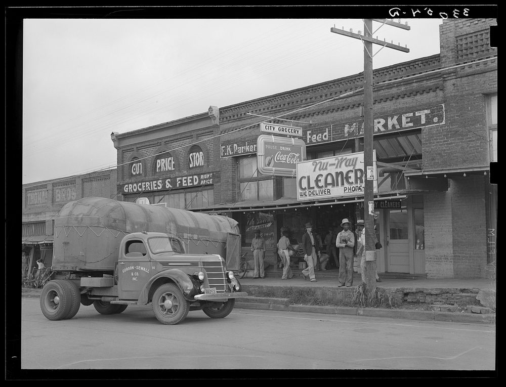 Wholesale grocery truck in front of grocery store. San Augustine, Texas by Russell Lee
