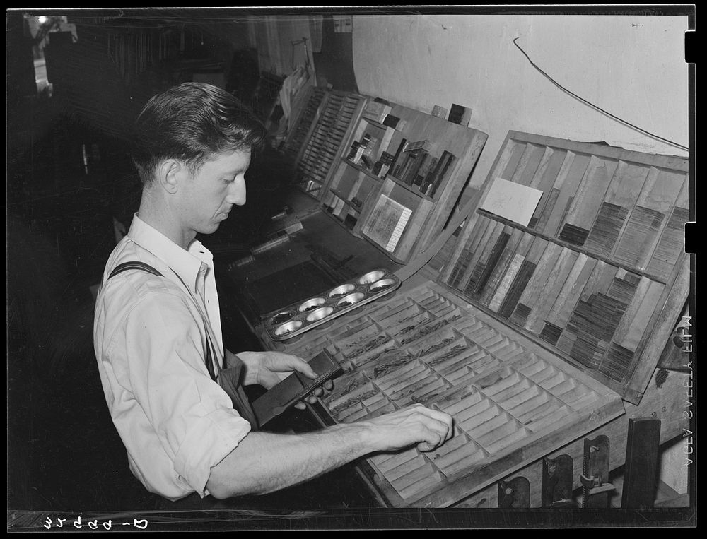 Setting type by hand. Newspaper office. San Augustine, Texas by Russell Lee
