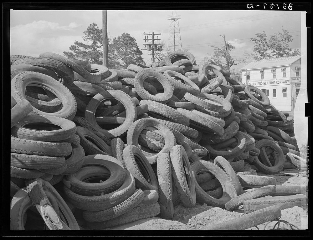 Piles of worn-out automobile tires in oil fields at Kilgore, Texas. Bad roads and heavy trucking in the oil fields cause…