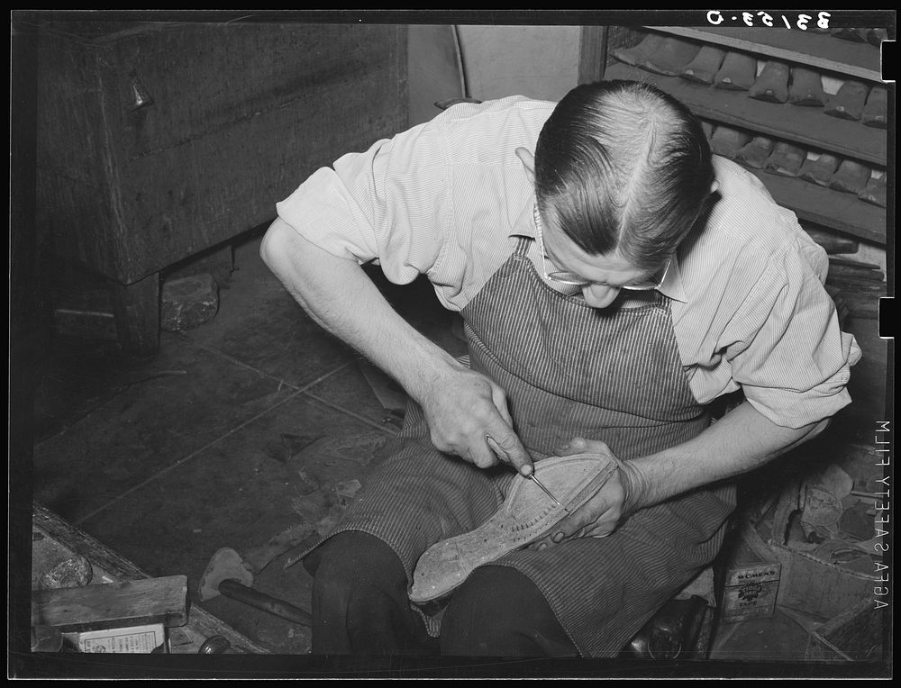 Cowboy bootmaker punching holes in inner sole in Goodyear welt method with awl. Cowboy bootmaking shop, Alpine, Texas by…