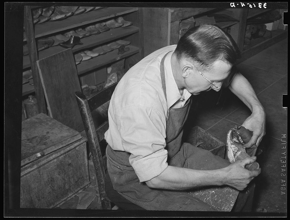 Bootmaker putting tack into upper part of boot before slipping in onto last and sole. Boot shop, Alpine, Texas by Russell Lee