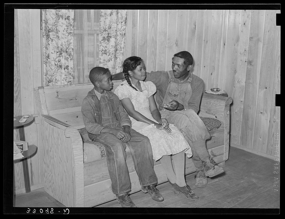FSA (Farm Security Administration) family in living room of home. Sabine Farms, Marshall, Texas by Russell Lee