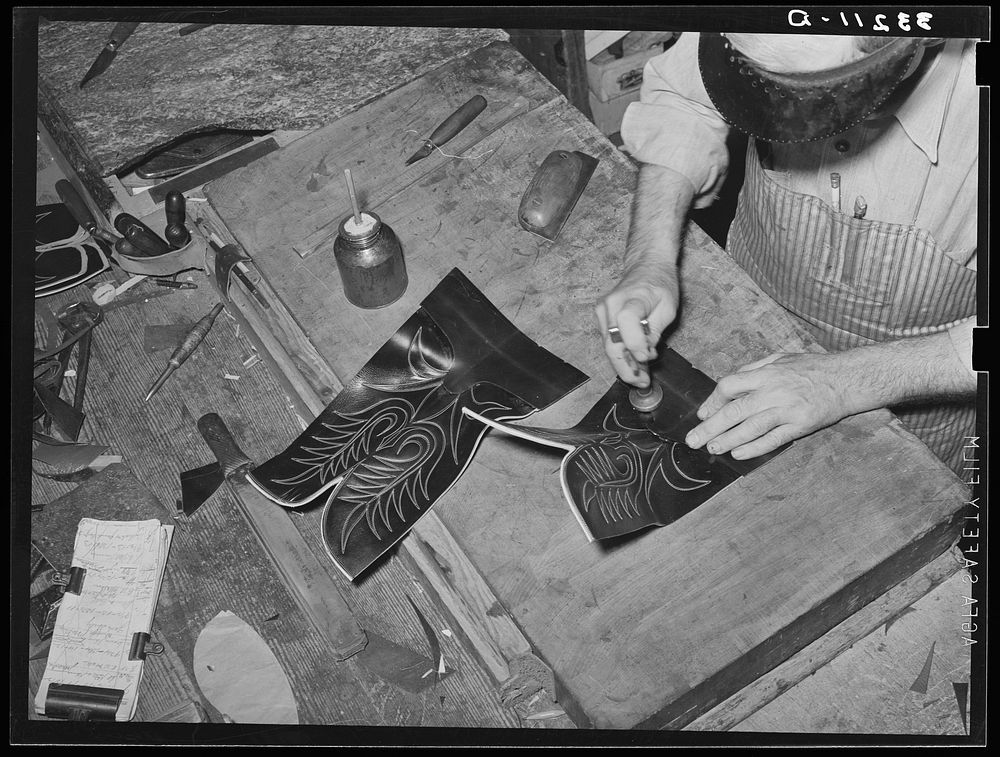 Tamping glued leather together after the heel section of uppers has been attached to stitched section of boot. Bootmaking…