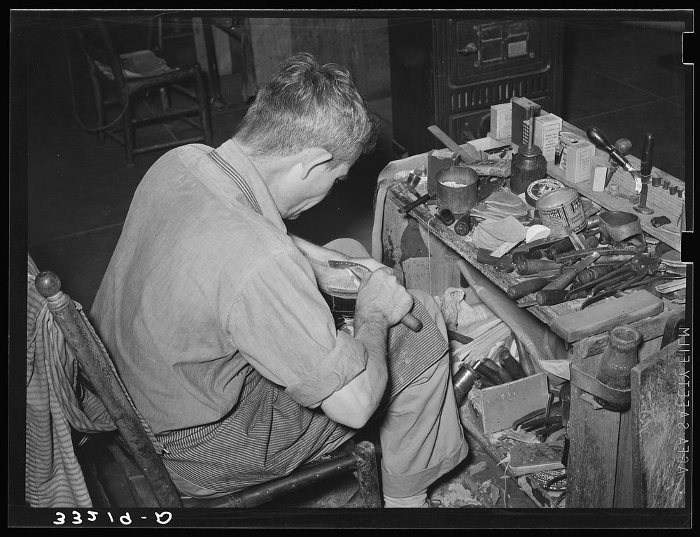 Bootmaker at work showing his workbench. Cowboy boot shop, Alpine, Texas by Russell Lee
