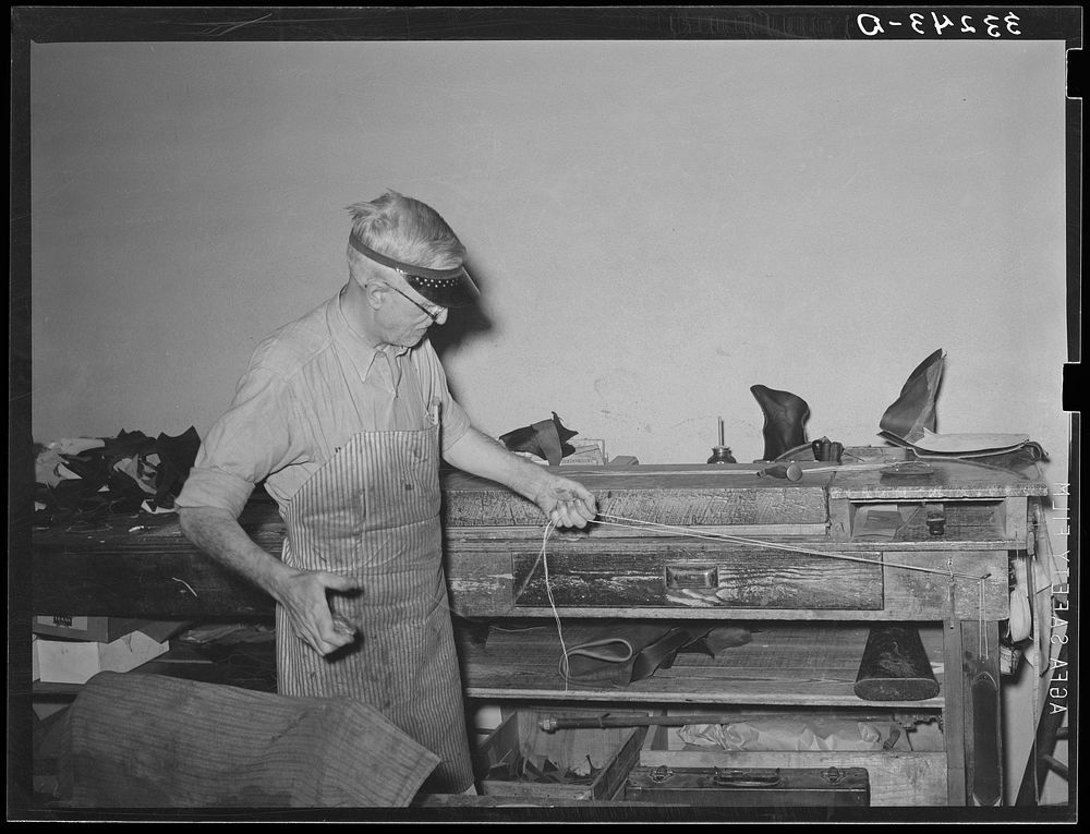 Waxing thread for use in sewing boots. Bootmaking shop, Alpine, Texas by Russell Lee