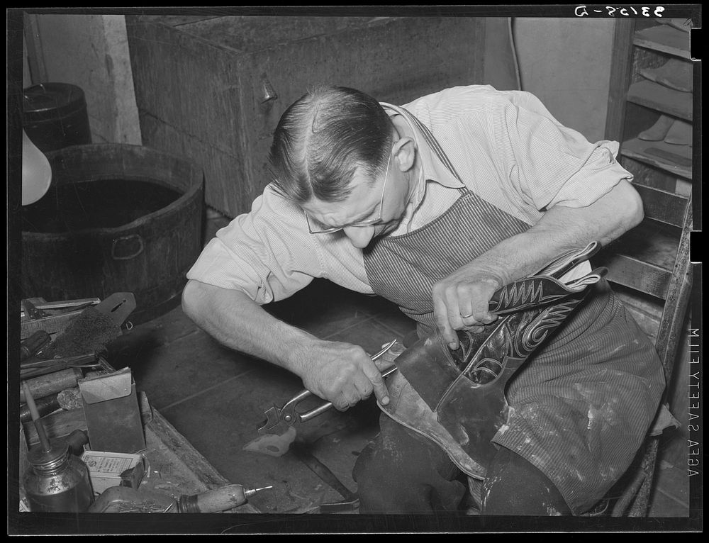 Bootmaker putting lower part of boot around the last for fitting. Bootmaking shop, Alpine, Texas by Russell Lee