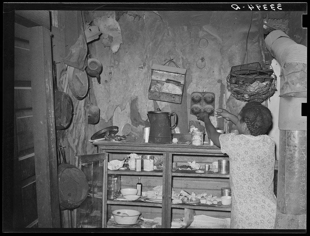 Kitchen cabinet in the home of  agricultural day laborer. Muskogee, Oklahoma. Note lunch pail by Russell Lee