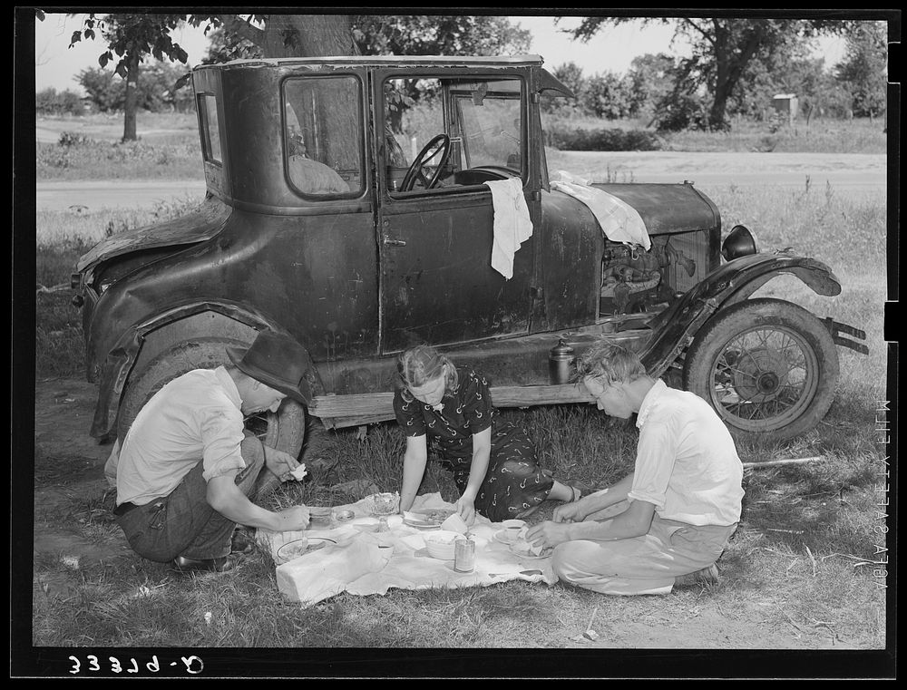 [Untitled photo, possibly related to: Migrant workers eating dinner by the side of their car while they are camped near…