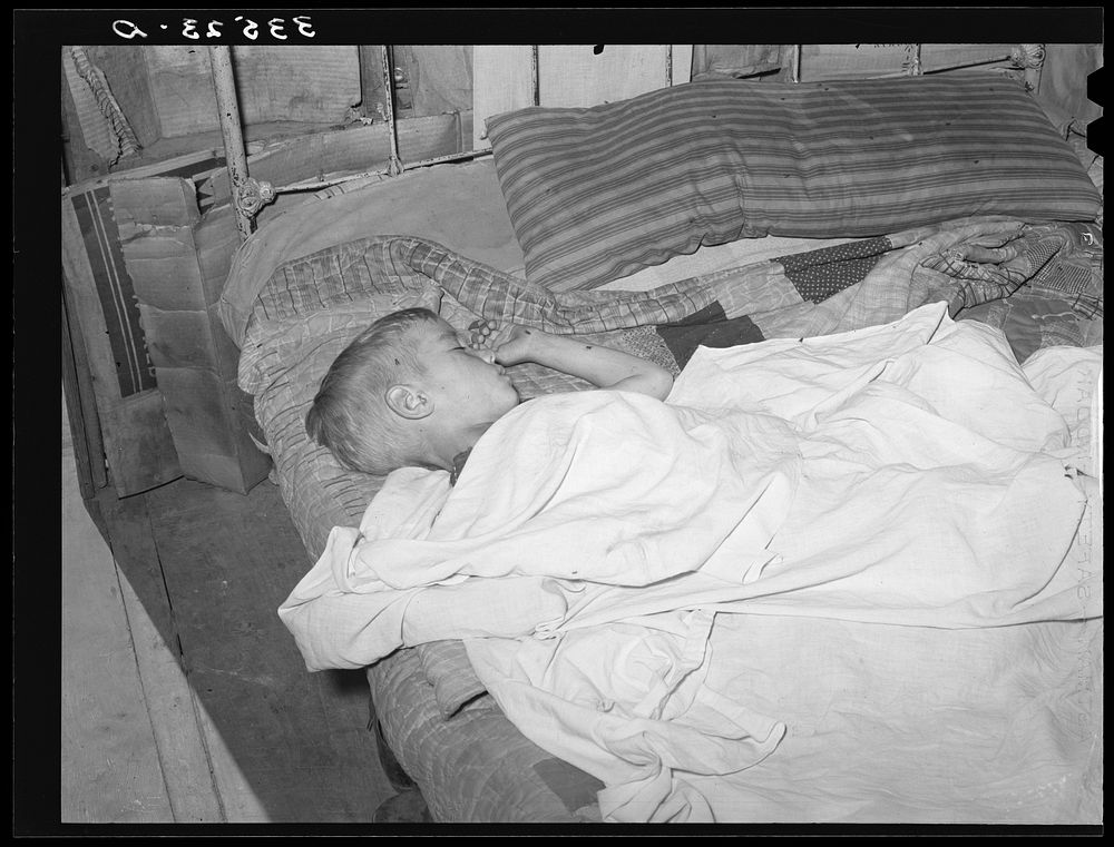 Boy asleep in house in Arkansas River bottom near Vian. Oklahoma, Sequoyah County by Russell Lee