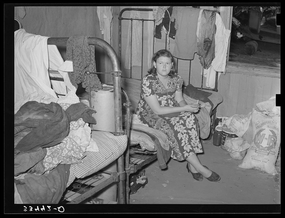 Member of migrant family group while they were camping near Muskogee, Oklahoma doing day labor to obtain funds to go to…