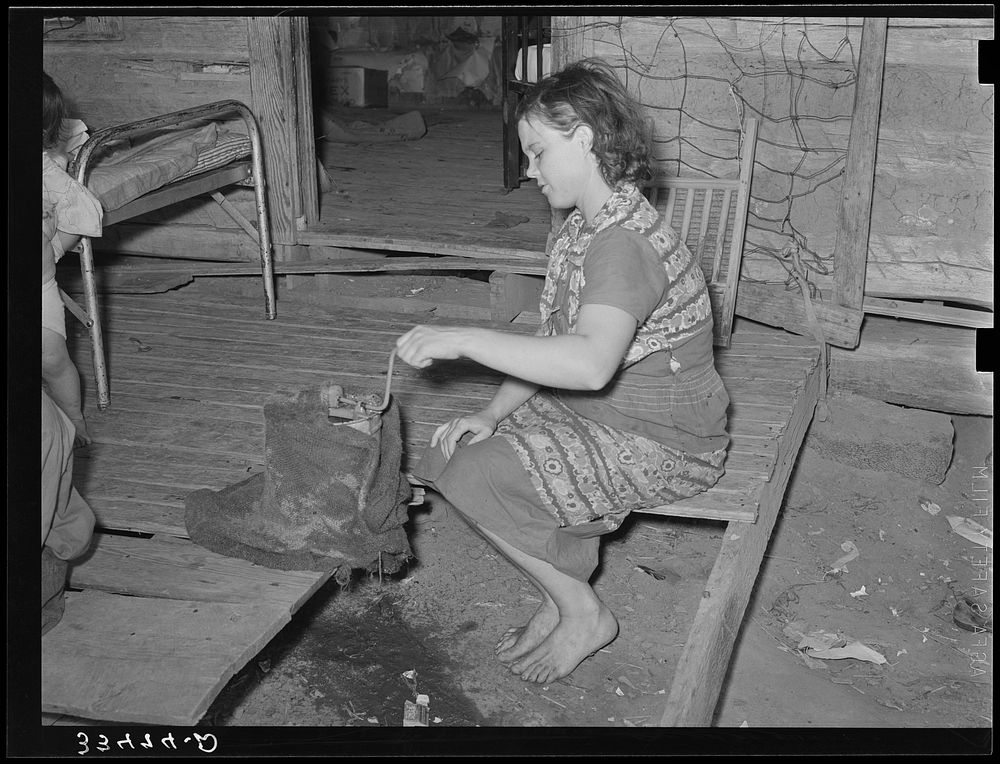 Wife of tenant farmer freezing ice cream on porch of her home near Warner, Oklahoma by Russell Lee