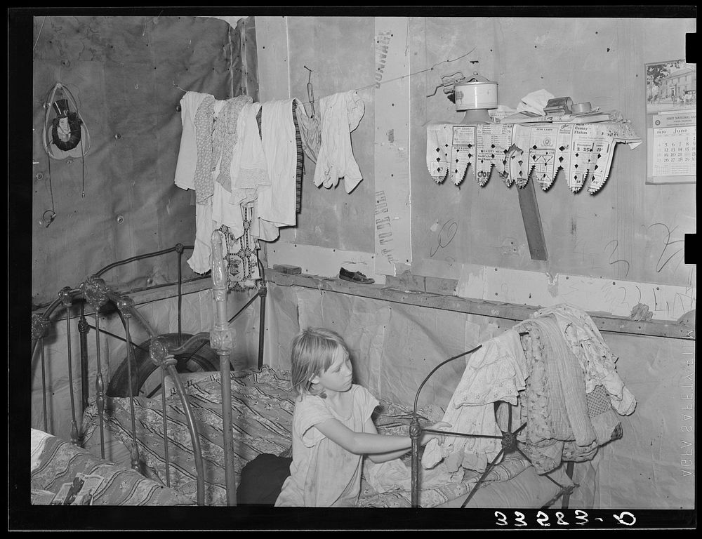 Interior of combined bedroom and living room of agricultural day laborer near Tullahassee, Oklahoma. Wagoner County by…