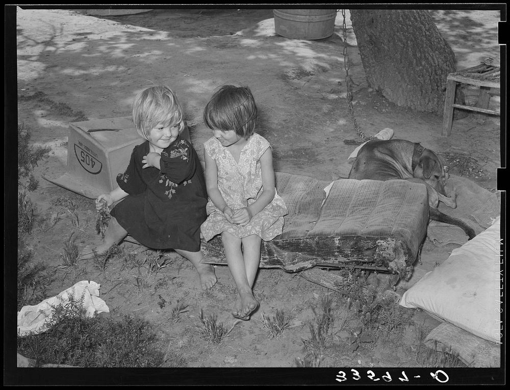 Children of agricultural day laborer sitting on an old automobile seat cushion. On Poteau Creek near Spiro, Oklahoma…