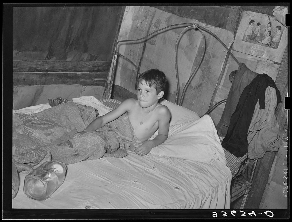 Young son of agricultural day laborer in bed. Near Vian, Oklahoma, Sequoyah County by Russell Lee