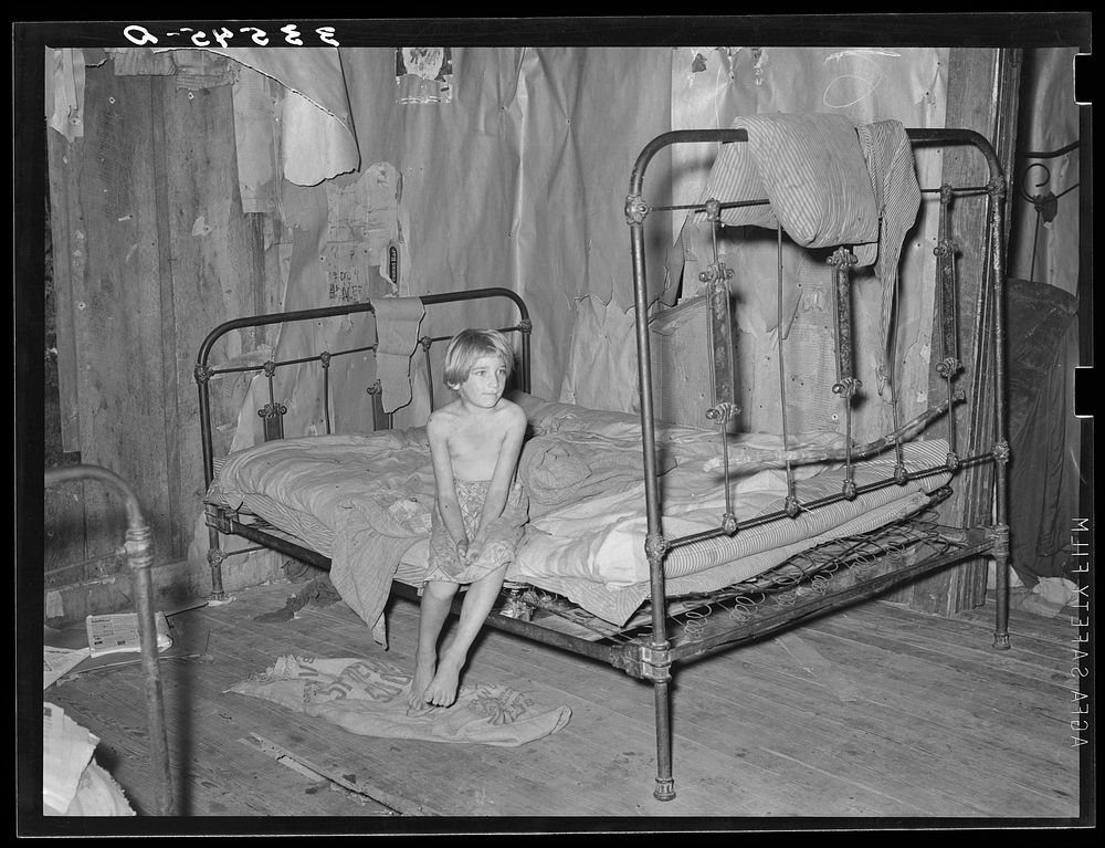 Daughter of agricultural day laborer in bedroom of home in McIntosh County, Oklahoma by Russell Lee