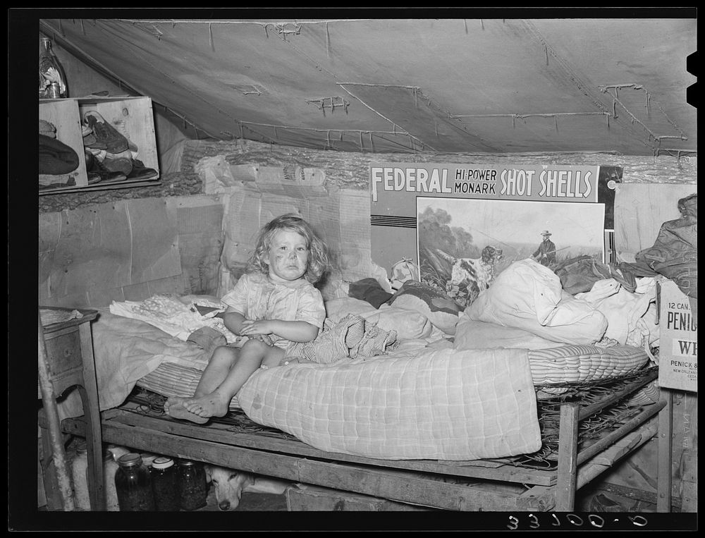 Child sitting on bed in tent home near Sallisaw, Oklahoma. Sequoyah County by Russell Lee