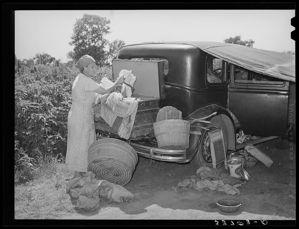 Belongings of migrant family packed in and around car near Muskogee, Oklahoma. Muskogee County by Russell Lee