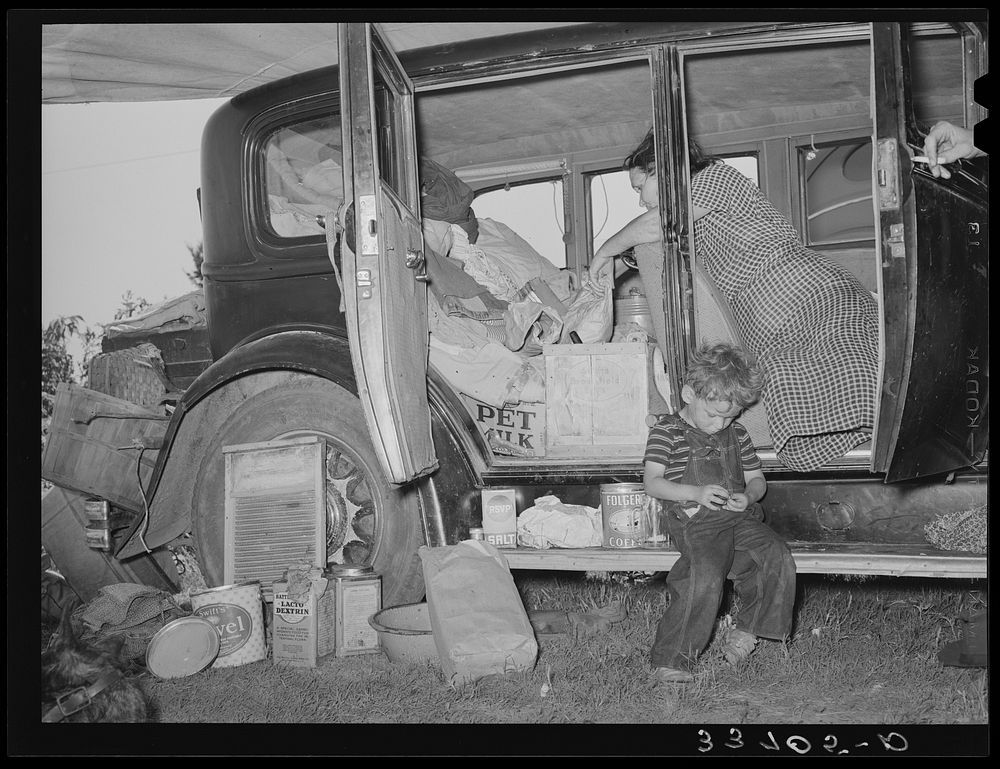 Belongings of migrant family packed in and around car near Muskogee, Oklahoma. Muskogee County by Russell Lee