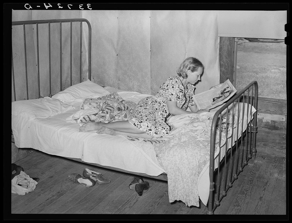 Daughter of woman tenant farmer reading magazine. Near Sallisaw, Oklahoma by Russell Lee