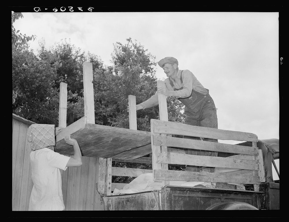 Loading table onto truck. Migrant family leaving from Muskogee enroute to California. Oklahoma by Russell Lee