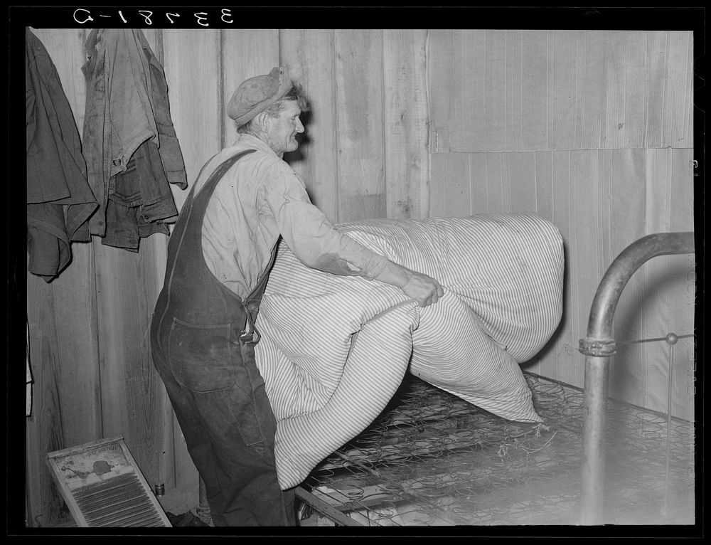 Elmer Thomas removing the mattress from bed which will be packed into truck enroute for California. Near Muskogee, Oklahoma…
