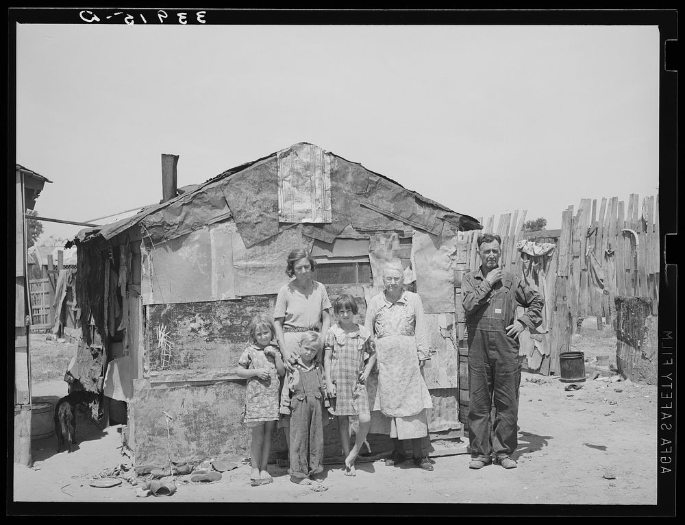 Family in front of shack home, Mays Avenue camp. Oklahoma City, Oklahoma. See general caption no. 21 by Russell Lee
