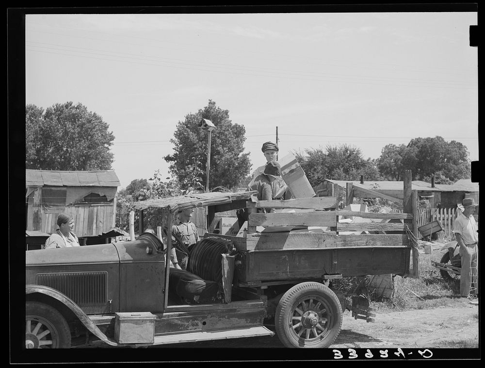 Unloading boxes from truck at shack home near Mays Avenue camp. Oklahoma City, Oklahoma. See general caption no. 21 by…