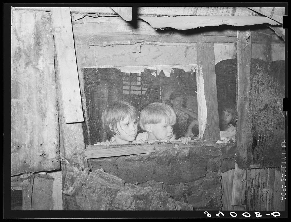 Children looking outside of window of shack home. Community camp, Oklahoma City, Oklahoma. See general caption no. 21 by…