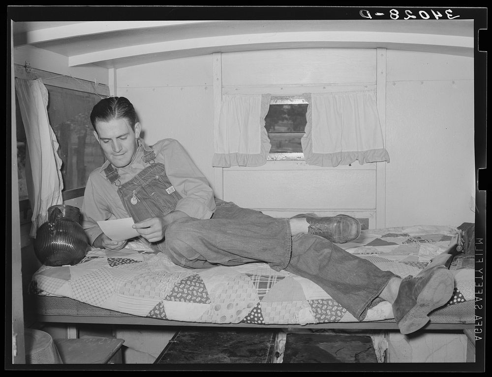 Oil field worker in his trailer home reading a letter. Seminole, Oklahoma by Russell Lee