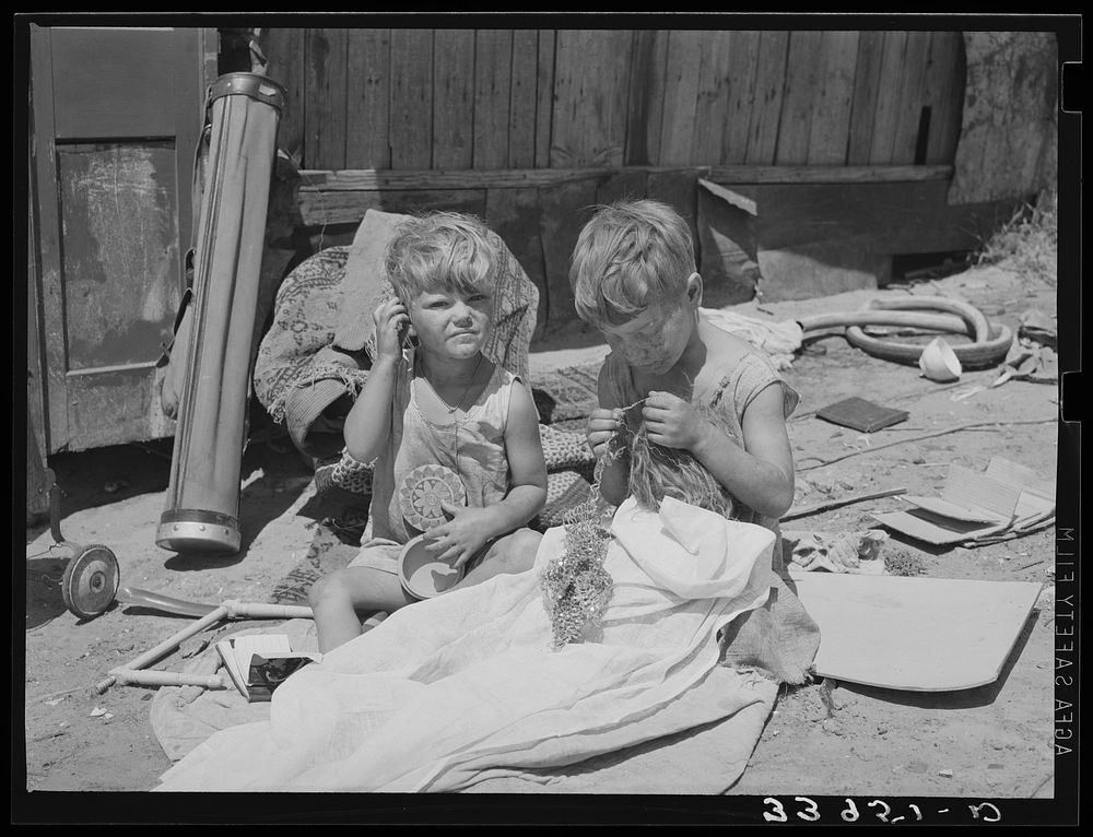 Children of Mays Avenue camp. Oklahoma City, Oklahoma. Their father is a trasher and they are playing with some things he…
