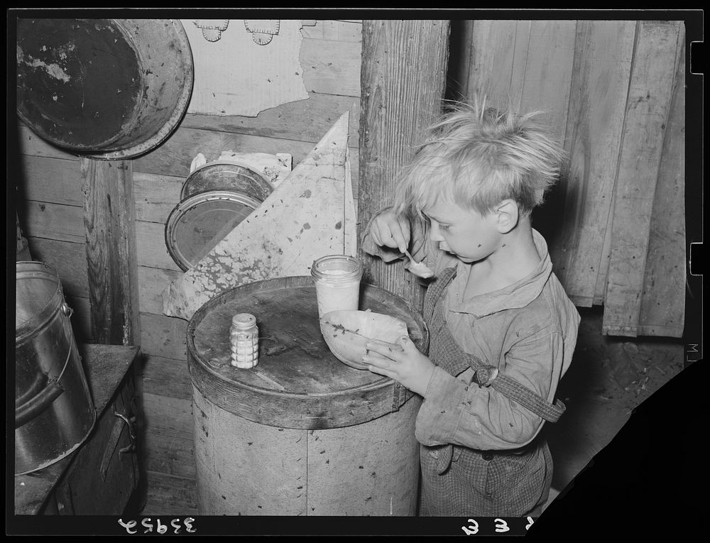 Child in Mays Avenue camp, Oklahoma City, Oklahoma, eating an overripe canteloupe found in market. See general caption 21 by…