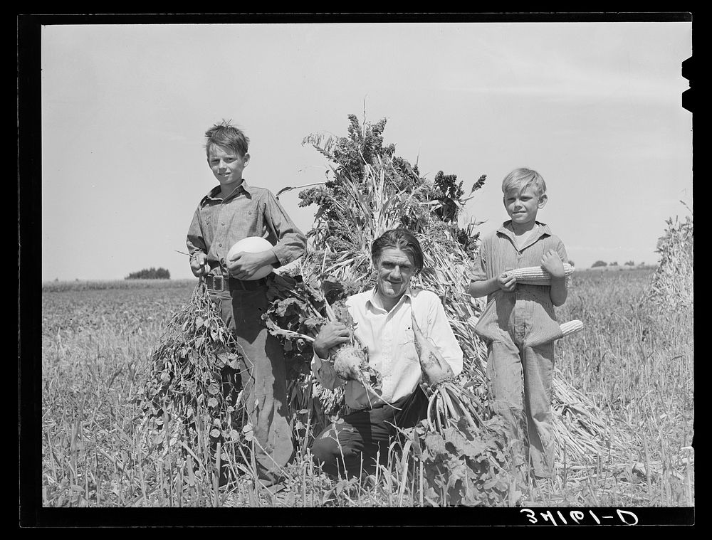 Ernest W. Kirk Jr. with his two sons on their farm near Ordway, Colorado. Fruits of their farm, coming from their labor…