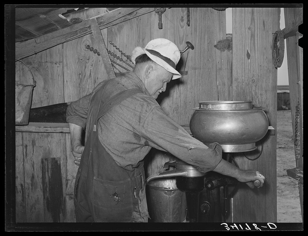 Mr. Bosley of Bosley reorganization unit, Baca County, Colorado, getting ready to start up the milk separator by Russell Lee