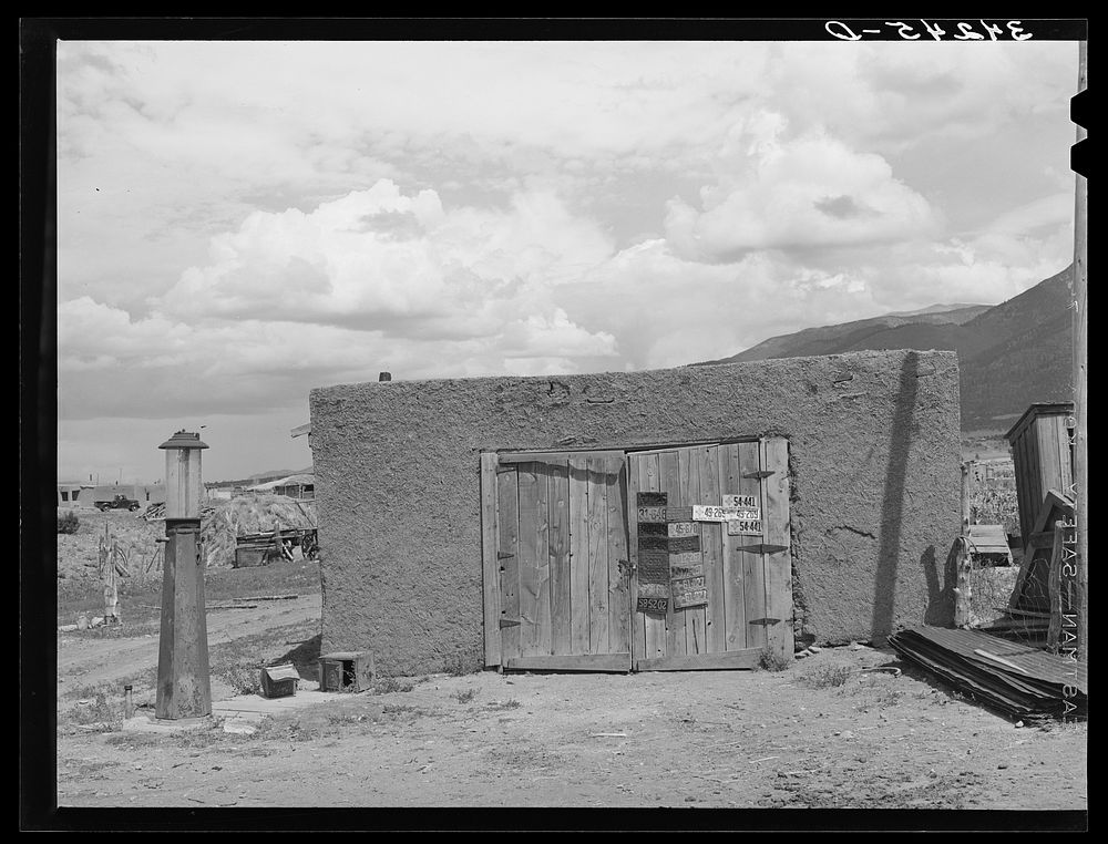 Garage and old gasoline pump on Spanish-American farm near Questa, New Mexico by Russell Lee