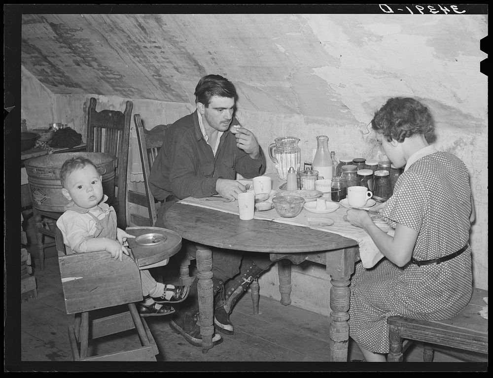 Son of family with his wife and child who live in an impoverished apartment on second floor of his family house. Orange…