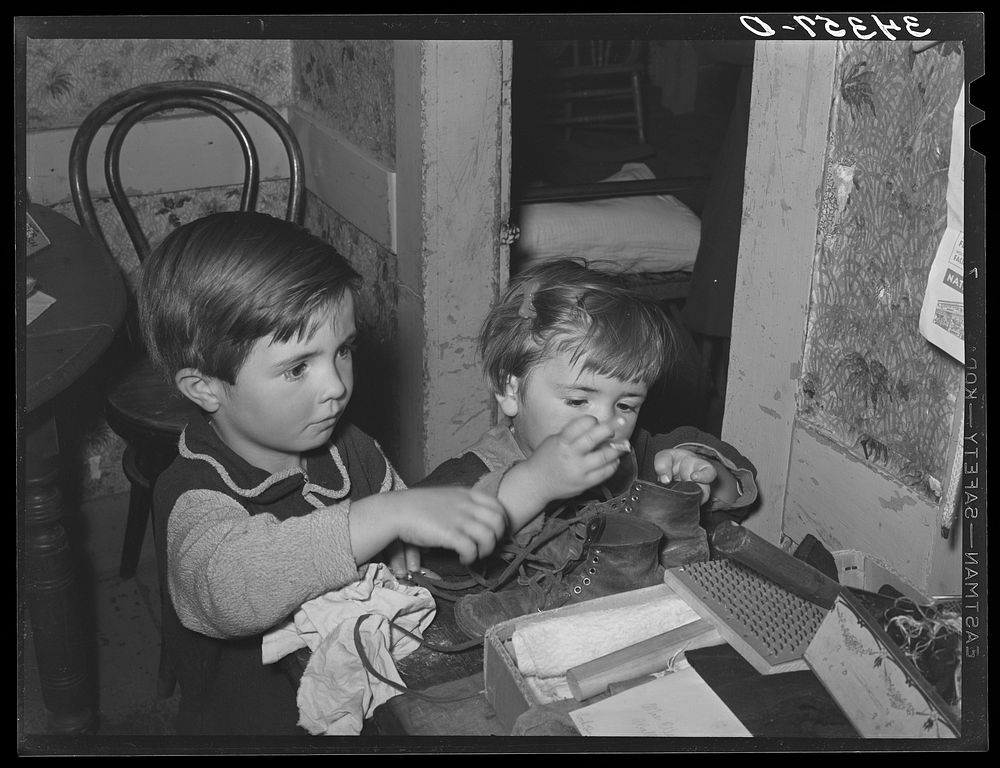 Farm children playing with articles on table. Farm home near Bradford, Vermont. Orange County by Russell Lee
