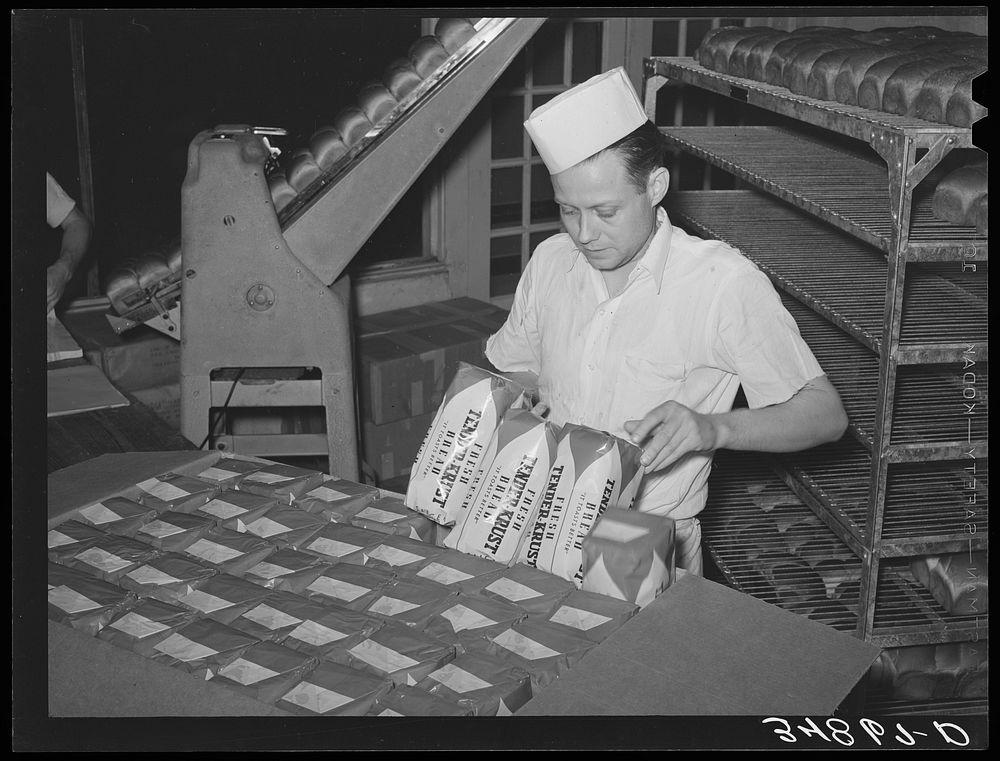 Packing wrapped bread into cartons for easy delivery. Bakery, San Angelo, Texas by Russell Lee