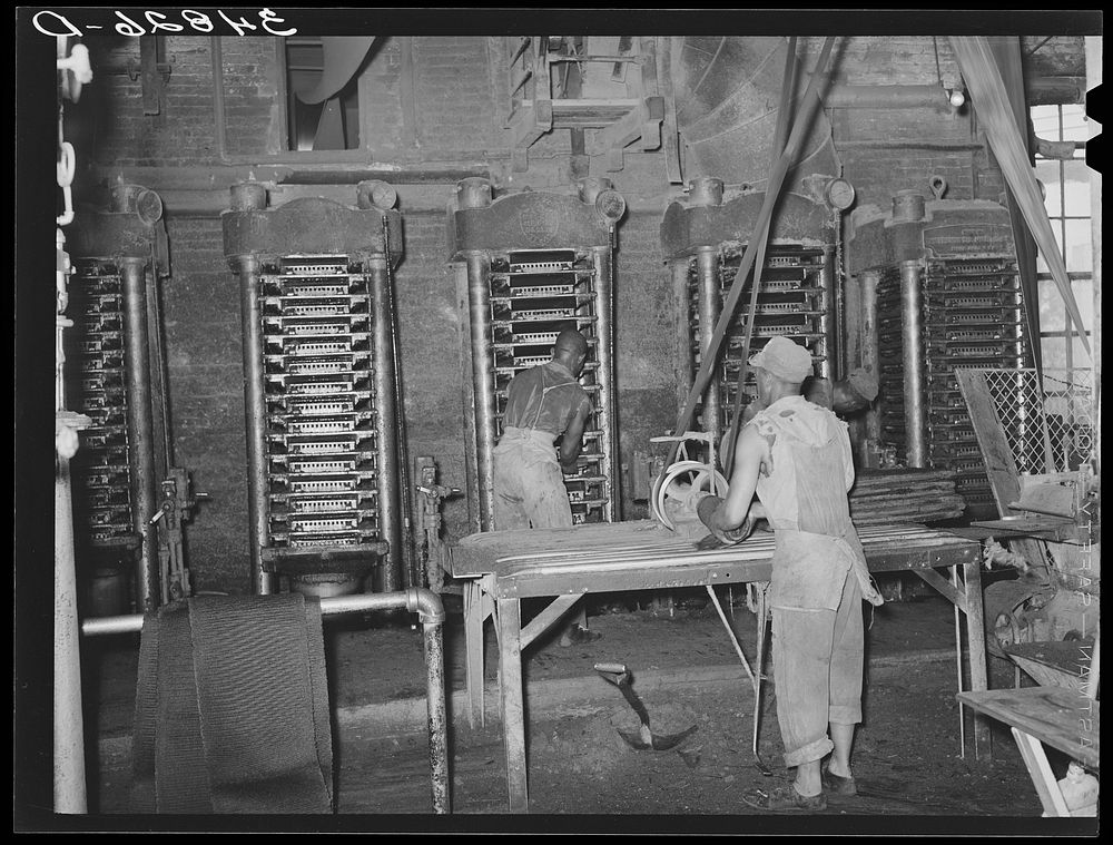 [Untitled photo, possibly related to: Removing cotton cake from hydraulic presses after oil has been removed. Cotton seed…