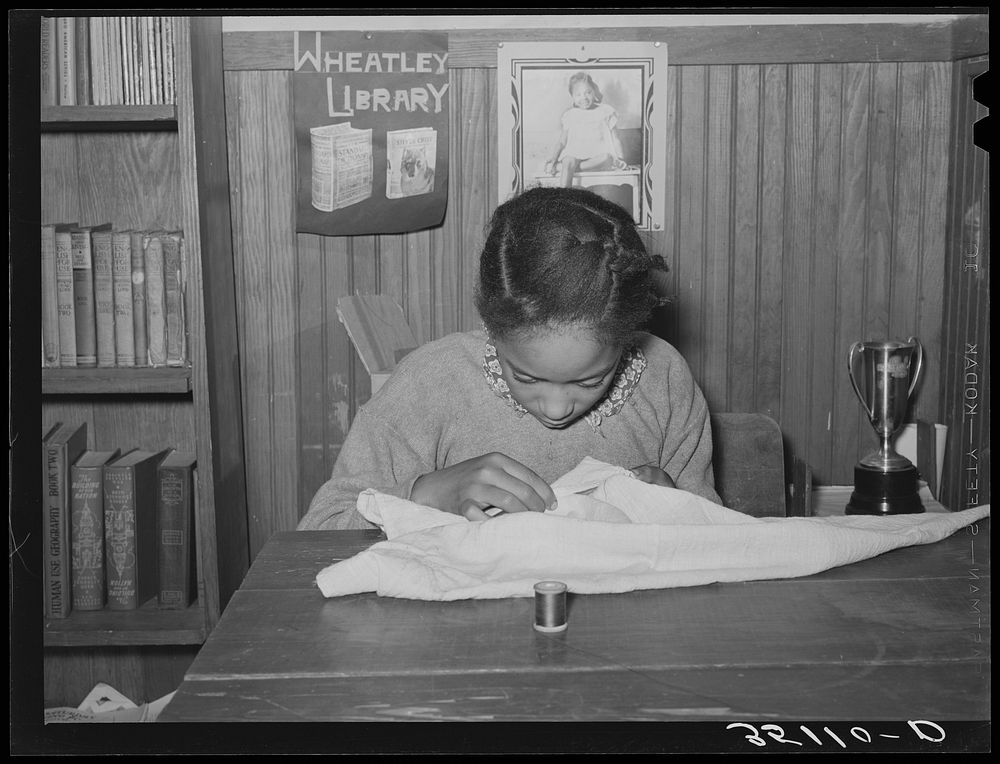 Daughter of Pomp Hall,  tenant farmer, sewing. Creek County, Oklahoma by Russell Lee