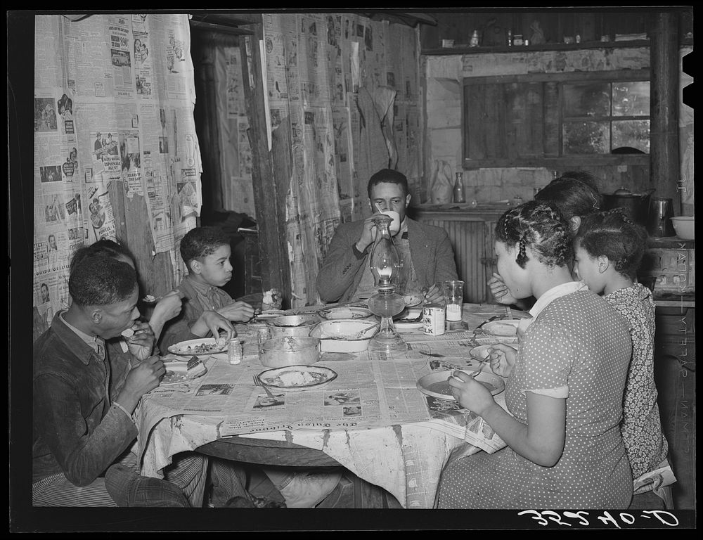 Pomp Hall, his wife, and five children eating supper. Creek County, Oklahoma. See general caption number 23 by Russell Lee