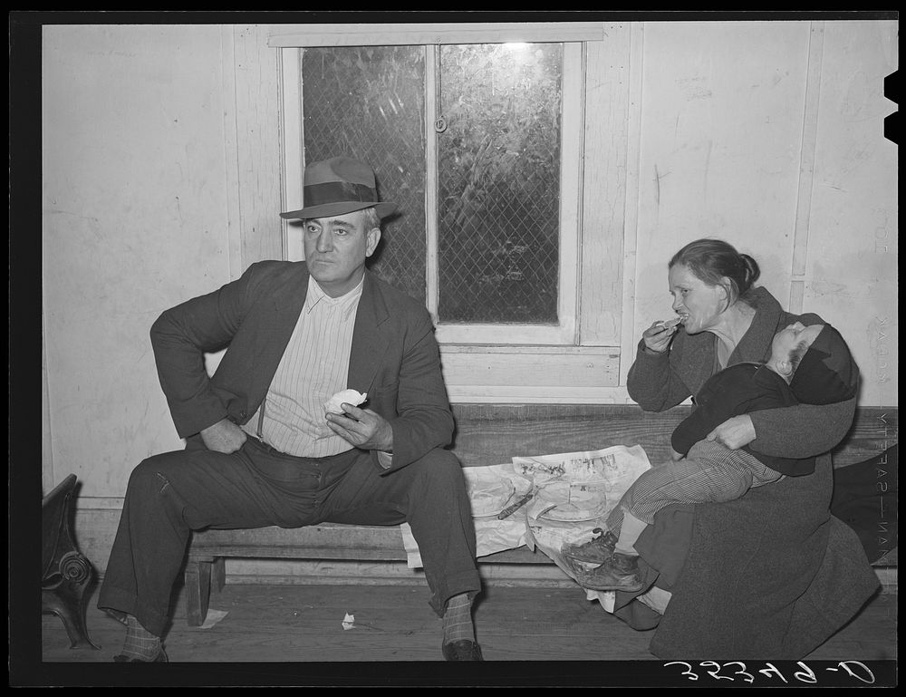 Farmer with his wife and child eating pie at pie supper. McIntosh County, Oklahoma. See general caption number 24 by Russell…