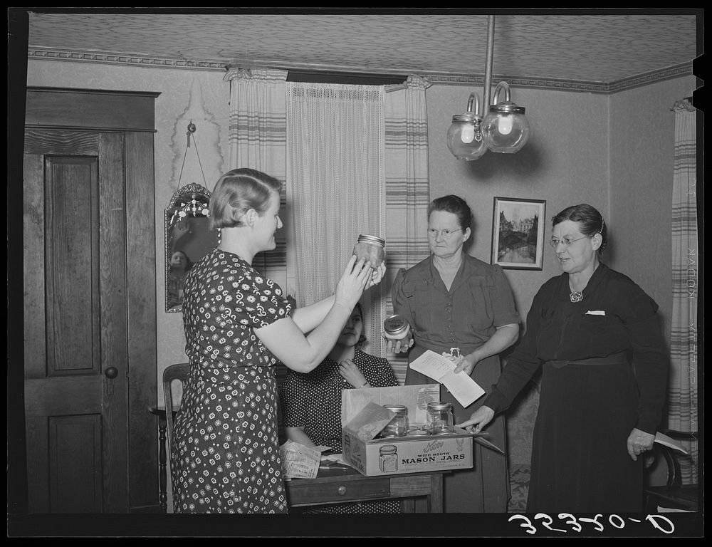 President of home demonstration club exhibiting a new type of Mason jar for canning purposes. McIntosh County, Oklahoma by…