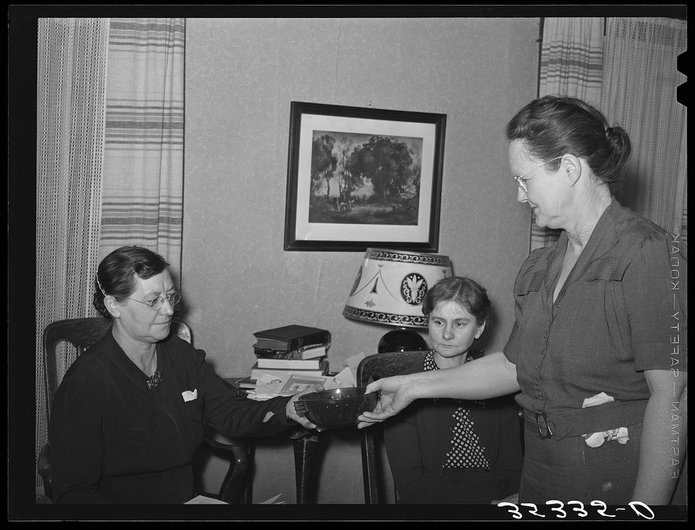 Hostess presenting prize which is a green glass bowl to the winner of a contest. The contest was to determine who could make…