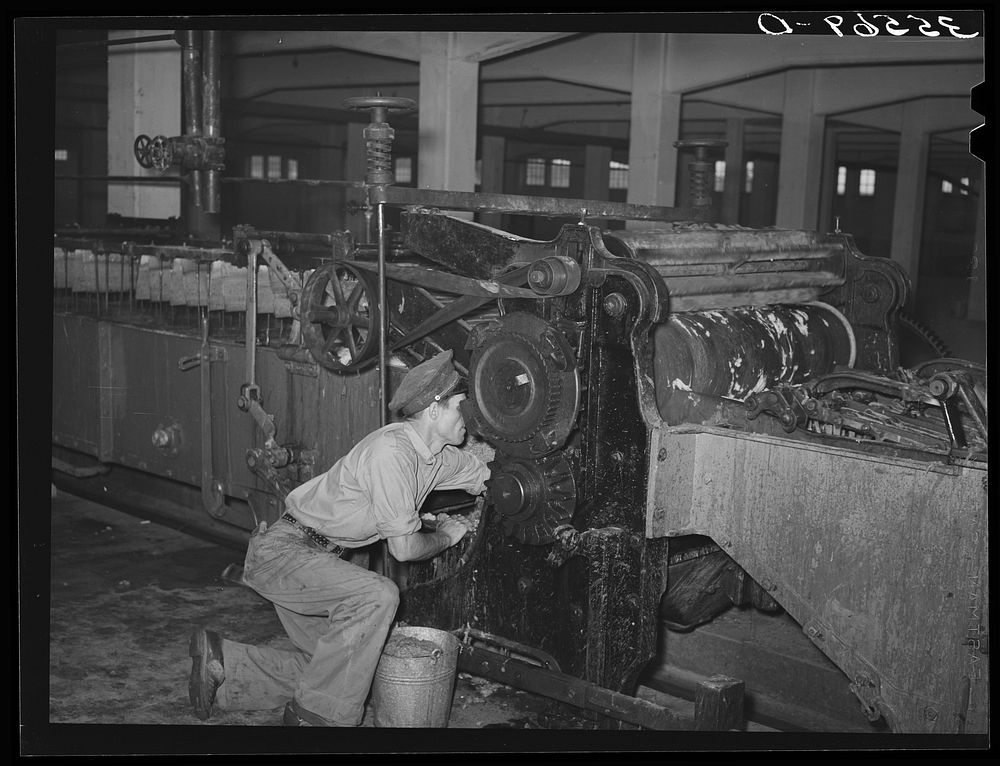 Workman cleaning wool scouring machine. San Marcos, Texas by Russell Lee