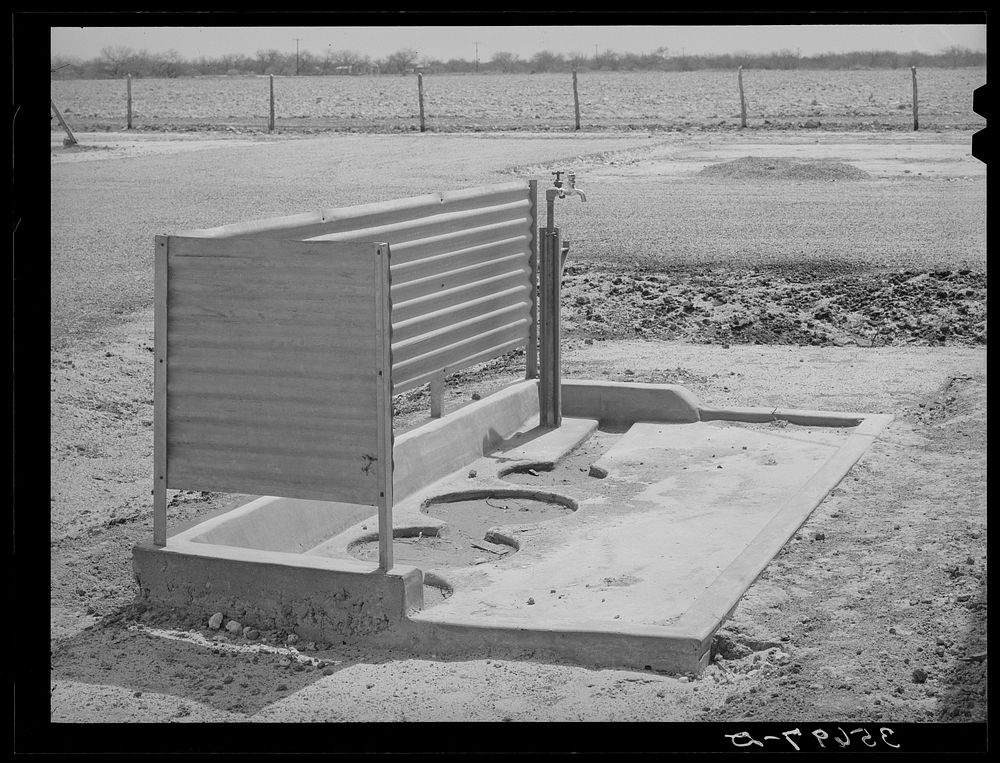 Water faucets and places for garbage cans which are designed to serve several units at the migratory labor camp. Sinton…