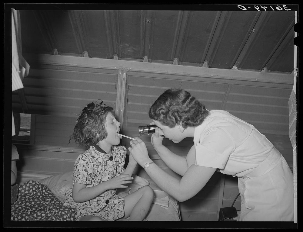 Nurse examining child of migratory laborer in family metal shelter at the Agua Fria migratory labor camp. Arizona by Russell…