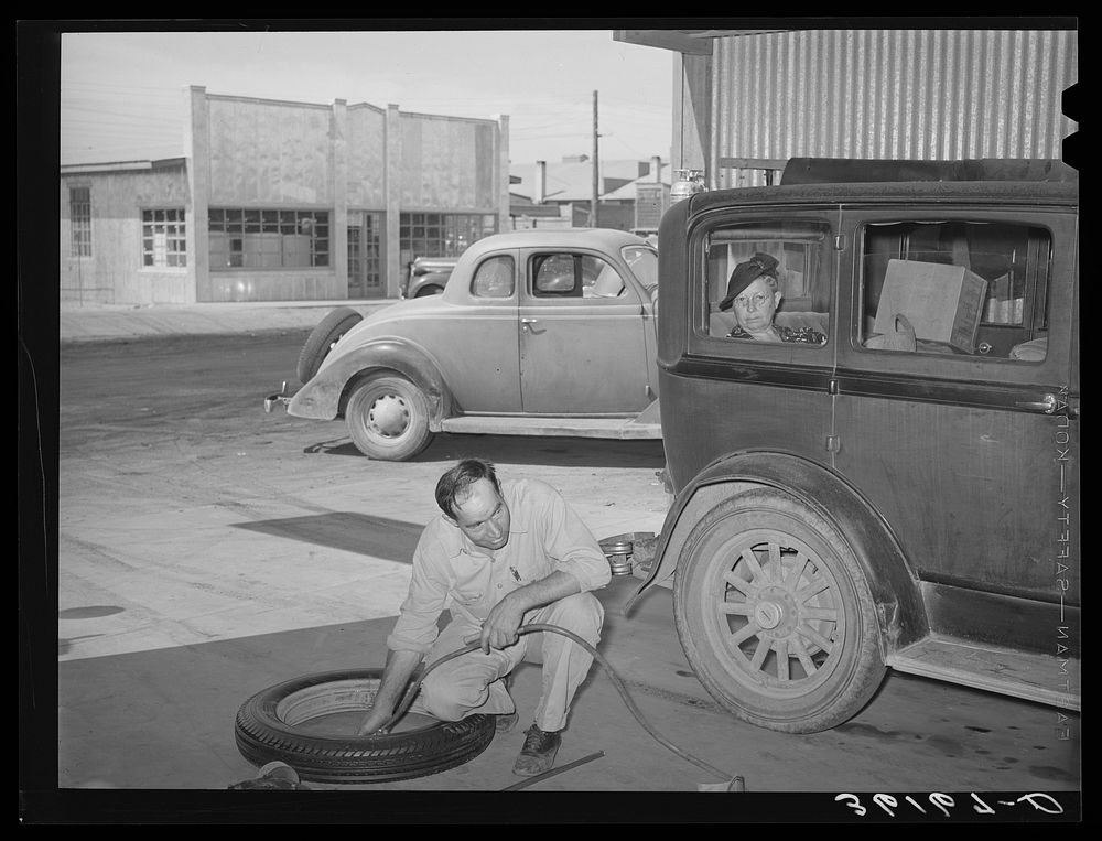 Inflating a new tire for installation on car of member of the United Producers and Consumers Cooperative. Phoenix, Arizona…