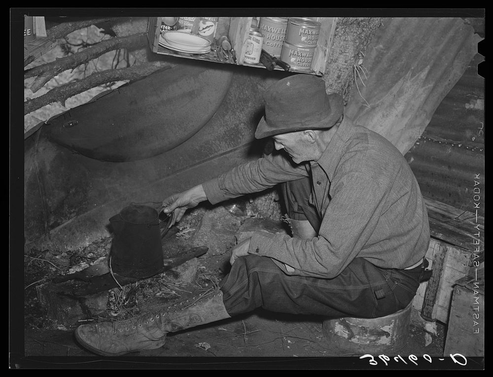 Eugene Davis, gold prospector, making a pot of coffee in his shack on his diggings at Pinos Altos, New Mexico by Russell Lee
