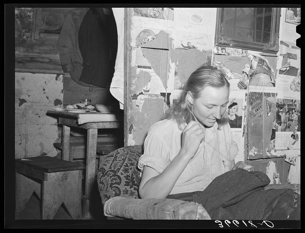 Mrs. Faro Caudill patching her husband's trousers. Pie Town, New Mexico by Russell Lee